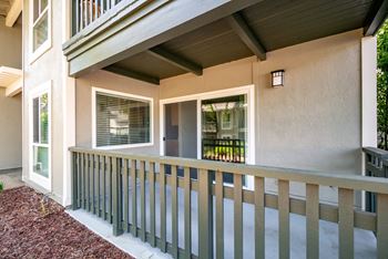 A porch of a house with a wooden railing